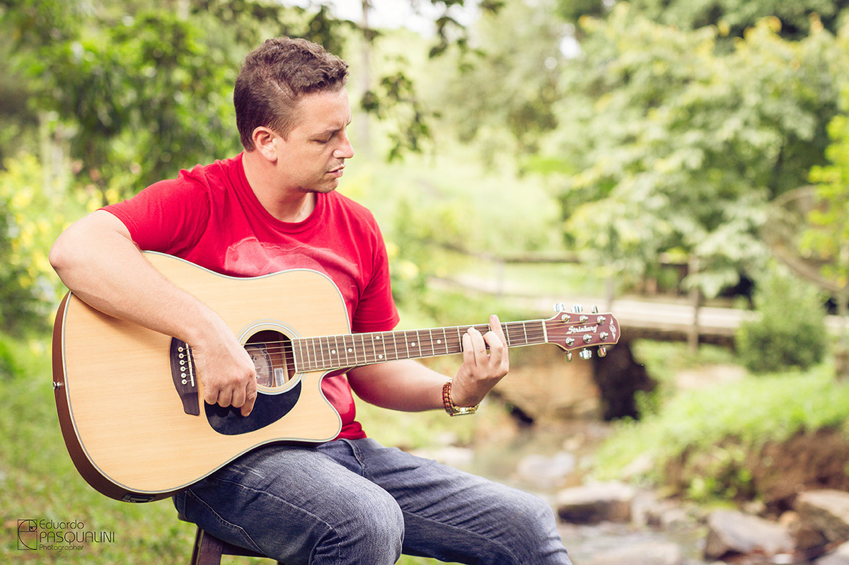 Tocando violão ao ar livre, na natureza. Foto de Eduardo Pasqualini, fotógrafo de casamentos e ensaios em Rio do Sul, Santa Catarina.