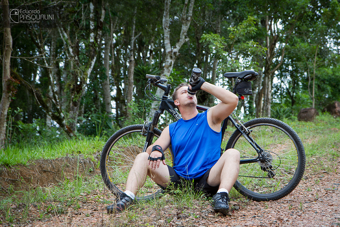Ciclista bebendo água em frete a bicicleta moutain bike. Foto de Eduardo Pasqualini, fotógrafo de casamentos e ensaios em Rio do Sul, Santa Catarina.