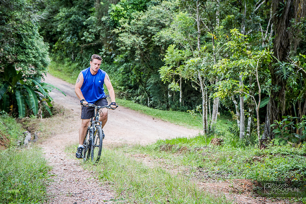 Pedalando bicicleta moutain bike morro acima, fazendo força. Foto de Eduardo Pasqualini, fotógrafo de casamentos e ensaios em Rio do Sul, Santa Catarina.