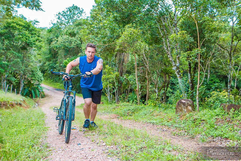 Empurrando bicicleta morro a cima em estrada de interior. Foto de Eduardo Pasqualini, fotógrafo de casamentos e ensaios em Rio do Sul, Santa Catarina.
