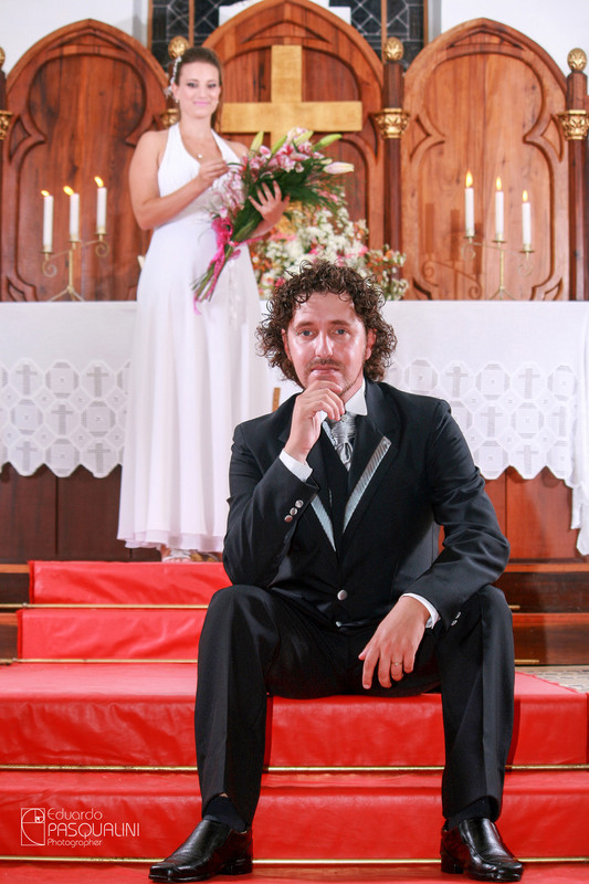 Sentado nos degraus do altar, noivo Fernando posa para foto. Fotografia de Eduardo Pasqualini, fotógrafo de casamentos e ensaios em Rio do Sul, Santa Catarina.