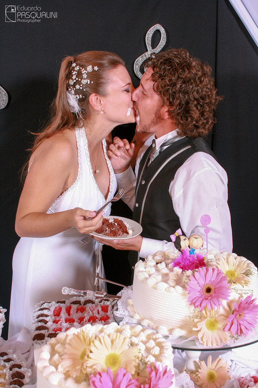 Beijo com bolo do casal Fernando e Ester. Fotografia de Eduardo Pasqualini, fotógrafo de casamentos e ensaios em Rio do Sul, Santa Catarina.