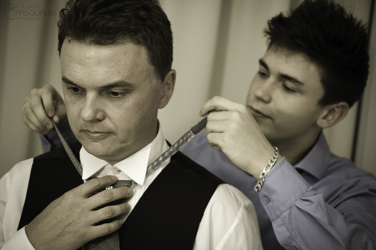 Filho arrumando gravata do pai para casamento. Fotografia de Eduardo Pasqualini, fotógrafo de casamentos e ensaios em Rio do Sul, Santa Catarina.