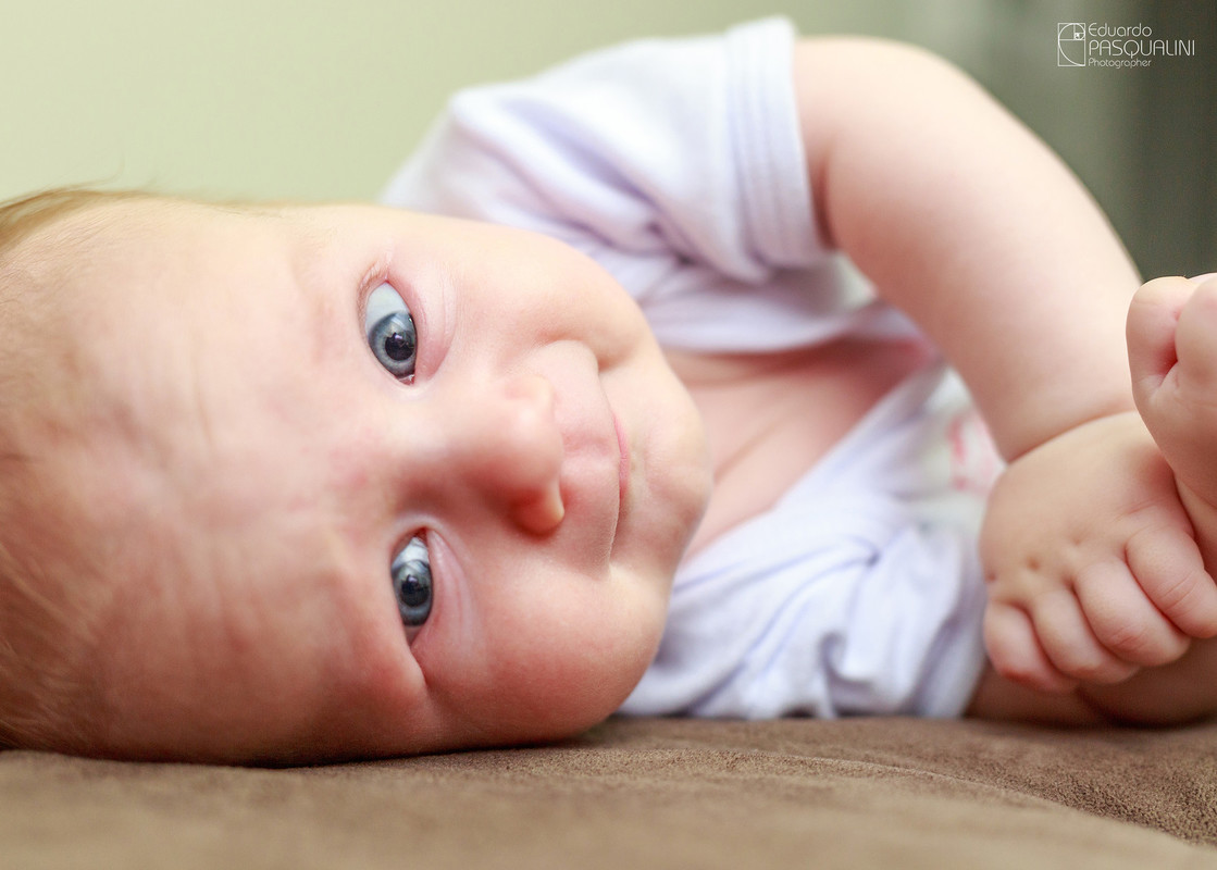 Bebe deitado olhando para a câmera. Fotografia de Eduardo Pasqualini, fotógrafo de casamentos e ensaios em Rio do Sul, Santa Catarina.