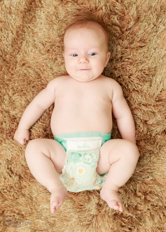 Baby de fraudas em cima de tapete peludo. Fotografia de Eduardo Pasqualini, fotógrafo de casamentos e ensaios em Rio do Sul, Santa Catarina.
