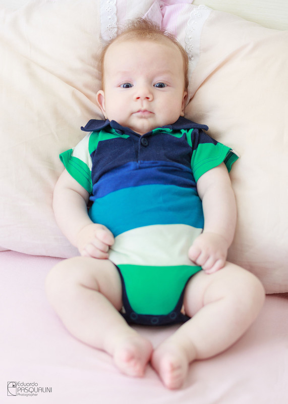 Criança de 2 meses encostado em almofadas. Fotografia de Eduardo Pasqualini, fotógrafo de casamentos e ensaios em Rio do Sul, Santa Catarina.