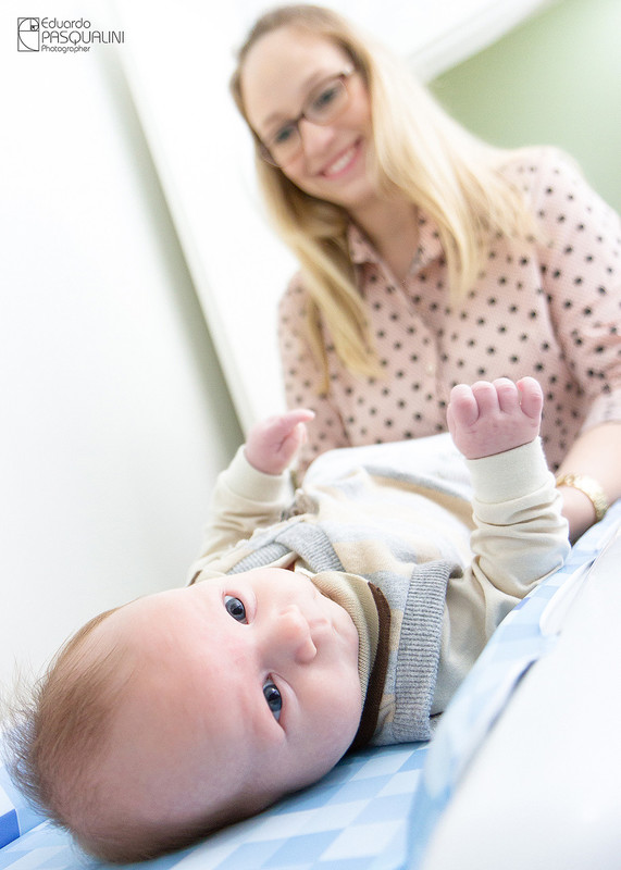 Mãe trocando frauda de bebe. Fotografia de Eduardo Pasqualini, fotógrafo de casamentos e ensaios em Rio do Sul, Santa Catarina.