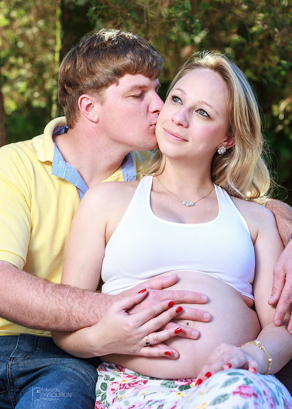Pai beijando no rosto gestante enquanto segura a barriga. Fotografia de Eduardo Pasqualini, fotógrafo de casamentos e ensaios em Rio do Sul, Santa Catarina.