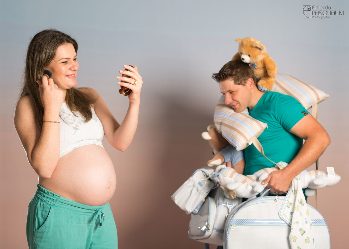 A mamãe Jane aproveitando que papai leva as malas do bebe. Ensaio de Gestante. Fotografia de Eduardo Pasqualini, fotógrafo de casamentos e ensaios em Rio do Sul, Santa Catarina.