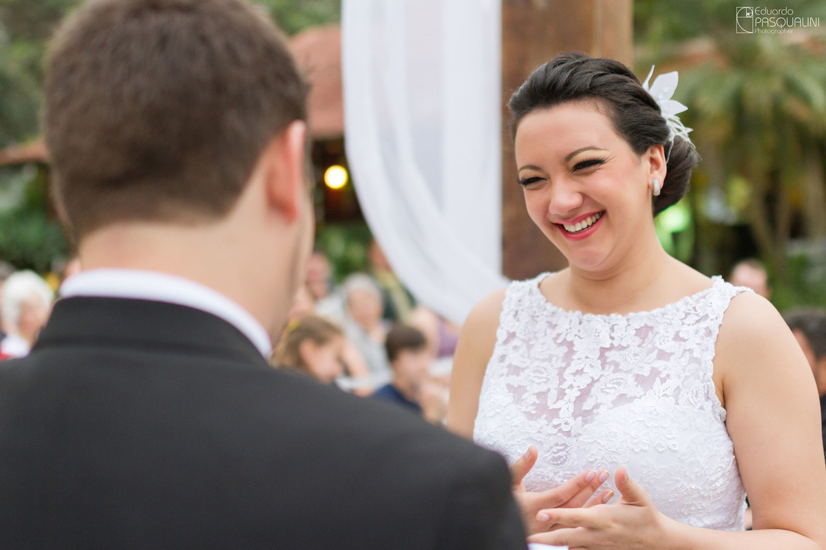 Noiva Daiane sorrindo para seu marido durante casamento. Fotografia de Eduardo Pasqualini, fotógrafo de casamentos e ensaios em Rio do Sul, Santa Catarina. Villa Viver.