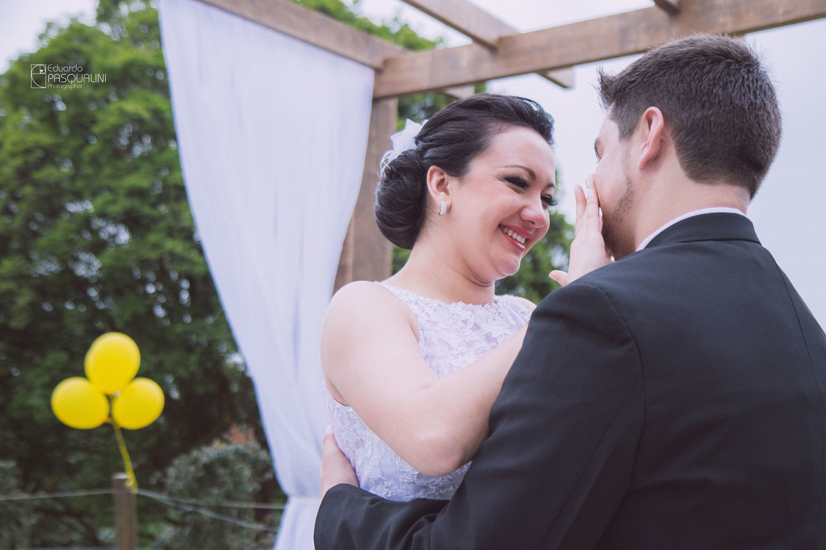 Daiane enxugando as lágrimas de noivo Rodnei durante casamento ao ar livre. Fotografia de Eduardo Pasqualini, fotógrafo de casamentos e ensaios em Rio do Sul, Santa Catarina. Villa Viver.