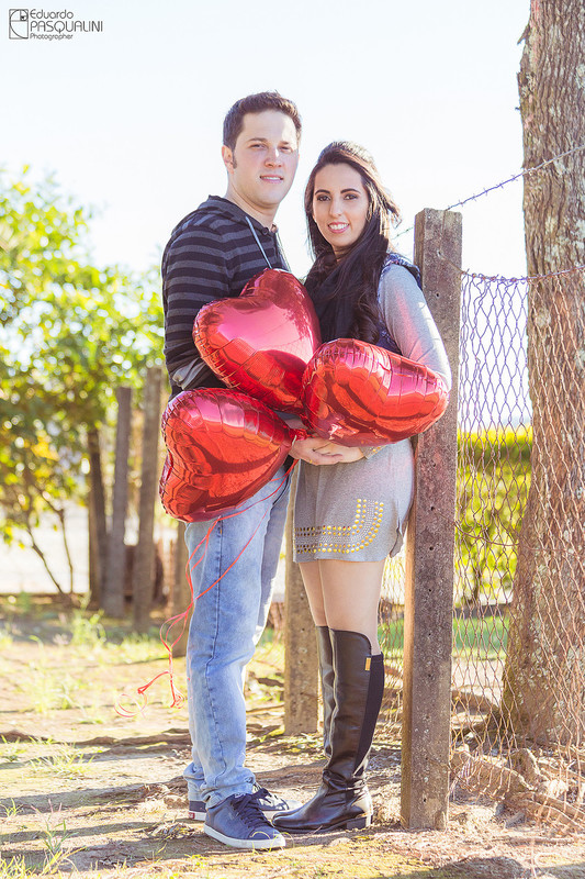 Segurando balões vermelhos, casal em ensaio pre-wedding. Fotografia de Eduardo Pasqualini, fotógrafo de casamentos e ensaios em Rio do Sul, Santa Catarina. Lontras.