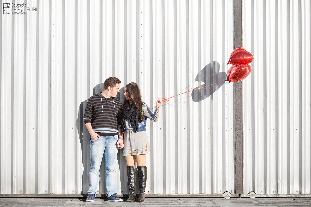 Portão branco de hangar de aviões no ensaio pré-Wedding. Fotografia de Eduardo Pasqualini, fotógrafo de casamentos e ensaios em Rio do Sul, Santa Catarina. Lontras.