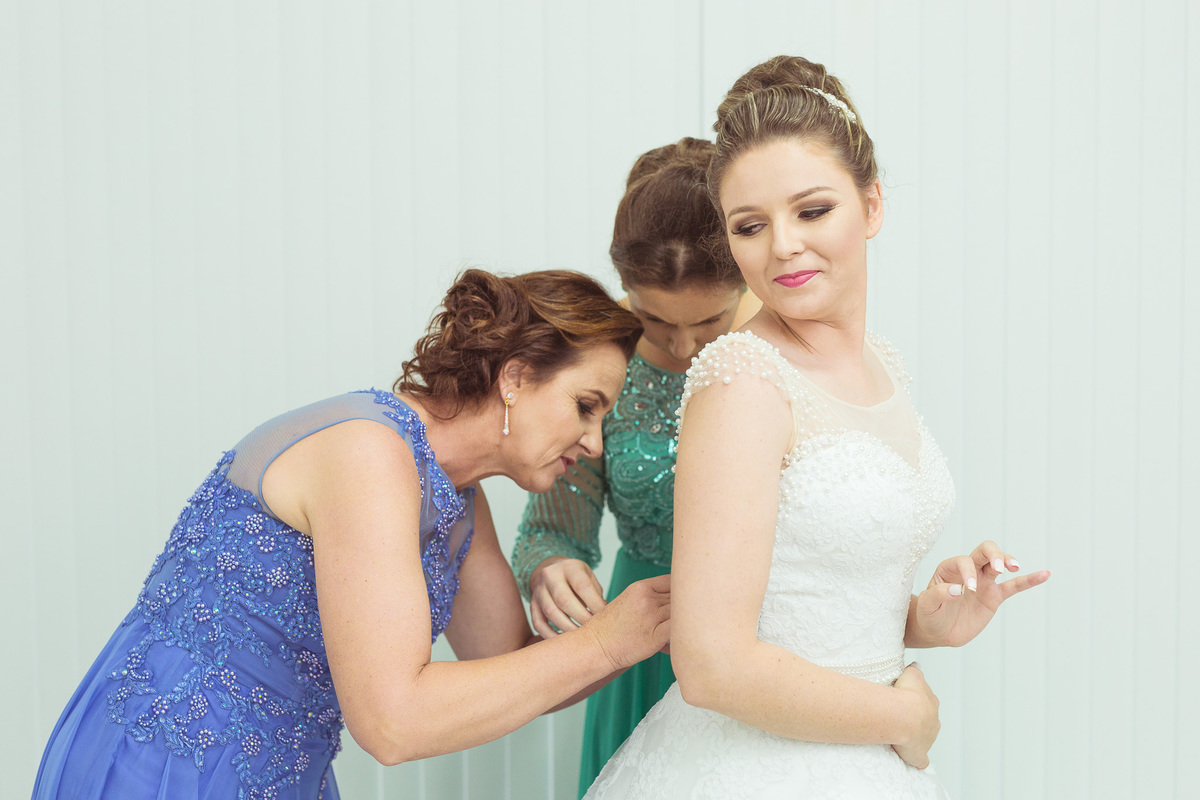 arrumando a noiva. Casamento Maiara e Alessandro. Presidente Nereu, SC. Fotografia de Eduardo Pasqualini, fotógrafo de casamentos e ensaios em Rio do Sul, Santa Catarina.