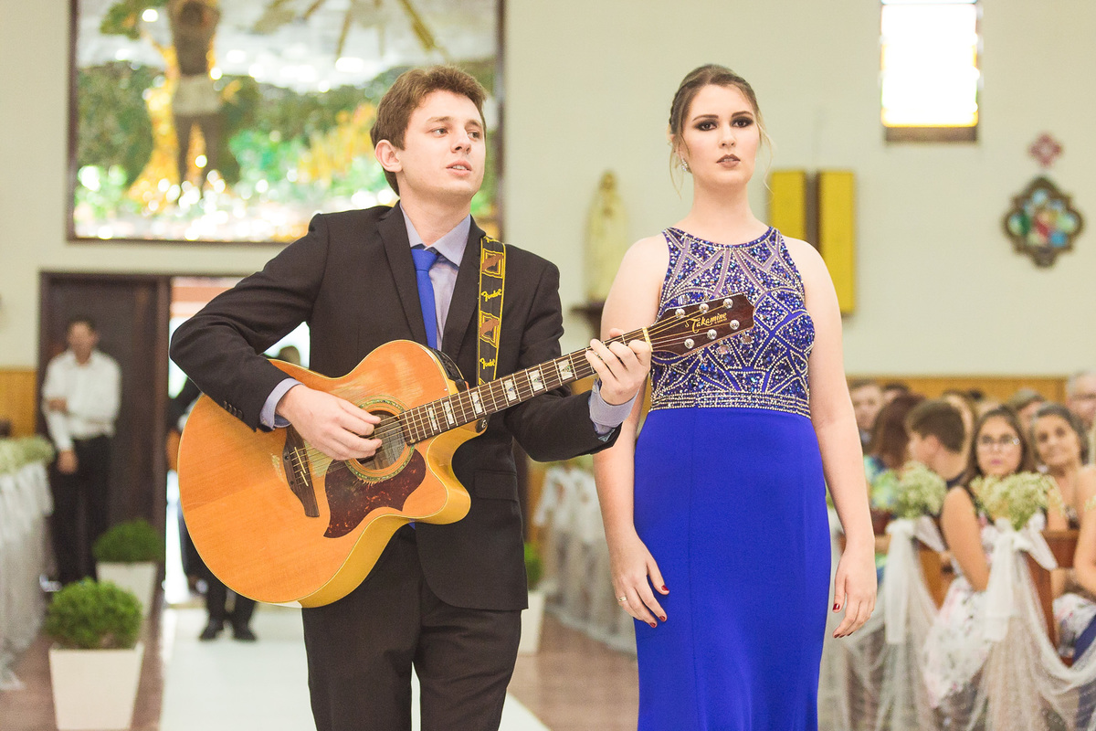 Padrinho tocando violão. Casamento Lidiane e Bruno, Vidal Ramos, SC, Clube Fluminense. Fotografia de Eduardo Pasqualini, fotógrafo de casamentos e ensaios em Rio do Sul, Santa Catarina.