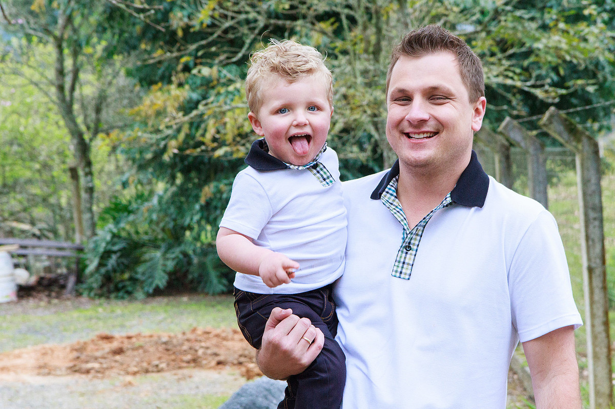Criança mostrando a linha feliz com seu pai. Fotografia de Eduardo Pasqualini, fotógrafo de casamentos e ensaios em Rio do Sul, Santa Catarina.