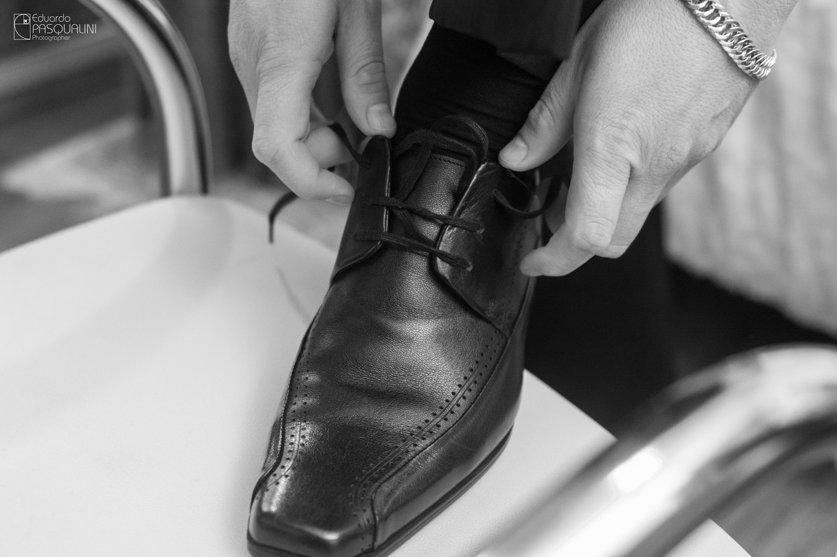 Colocando o sapato do noivo. Fotografia de Eduardo Pasqualini, fotógrafo de casamentos e ensaios em Rio do Sul, Santa Catarina.