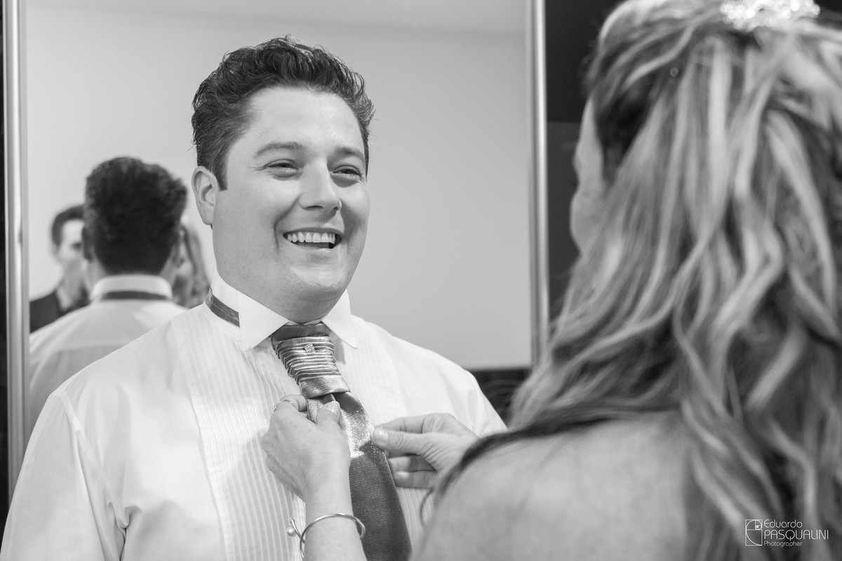 Noivo sendo vestido pela mãe, arrumando a gravata. Fotografia de Eduardo Pasqualini, fotógrafo de casamentos e ensaios em Rio do Sul, Santa Catarina.