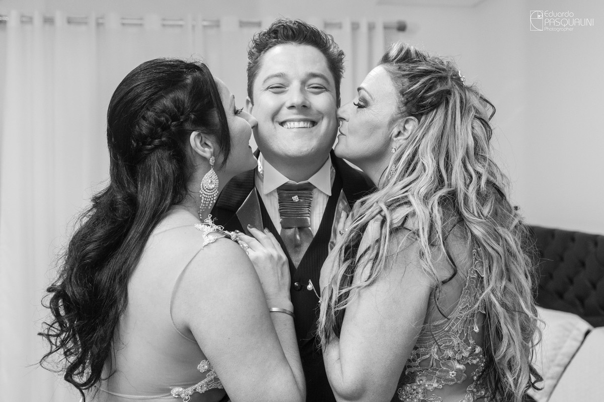 Irmã e mãe beijando o noivo no rosto. Fotografia de Eduardo Pasqualini, fotógrafo de casamentos e ensaios em Rio do Sul, Santa Catarina.