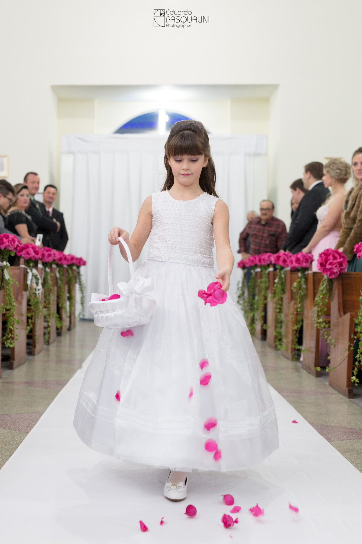 Daninha de honra preparando o caminho para a noiva com pétalas de rosas. Fotografia de Eduardo Pasqualini, fotógrafo de casamentos e ensaios em Rio do Sul, Santa Catarina.