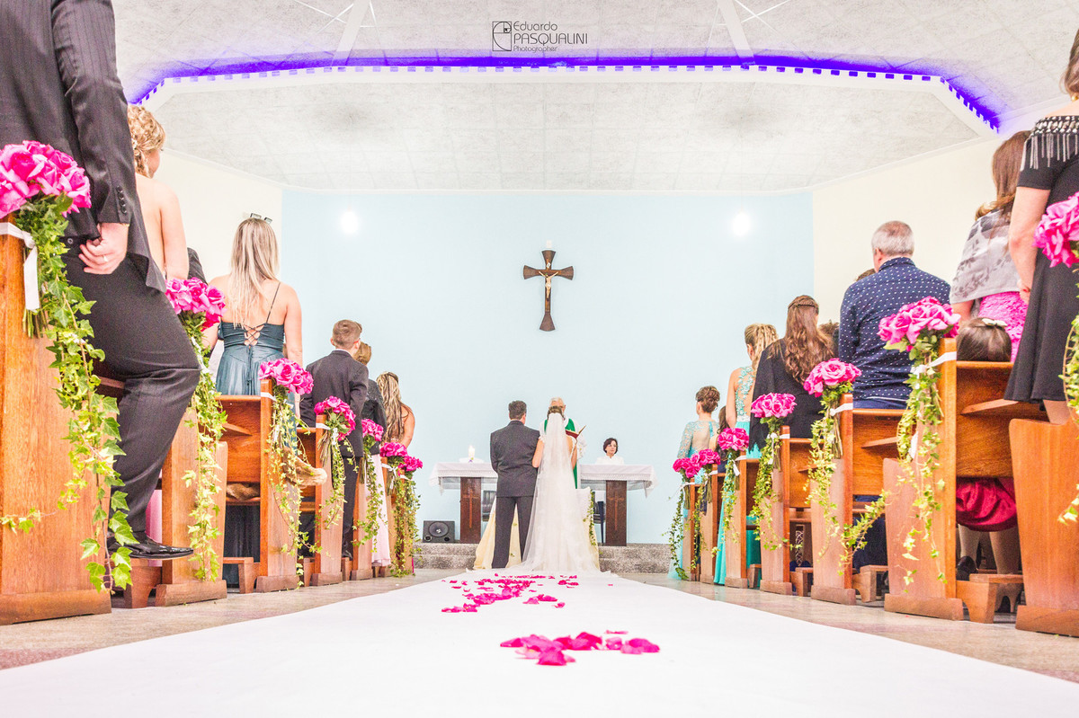 Igreja vista por trás com noivos no altar. Fotografia de Eduardo Pasqualini, fotógrafo de casamentos e ensaios em Rio do Sul, Santa Catarina.