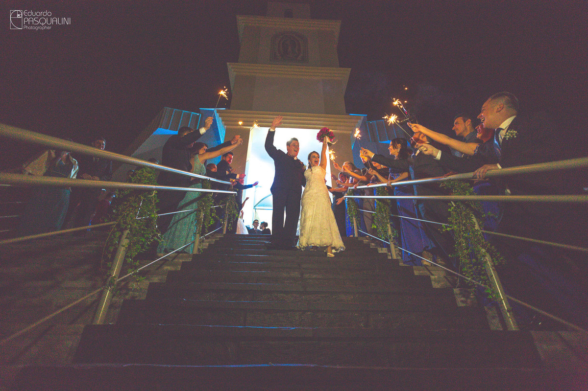 Comemorando nas escadas da igreja, casal de noivos Bruna e Anderson. Fotografia de Eduardo Pasqualini, fotógrafo de casamentos e ensaios em Rio do Sul, Santa Catarina.