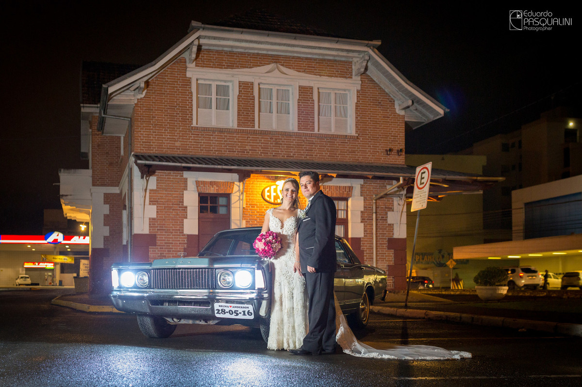 Em frente a carro antigo, casal de noivos Bruna e Anderson no museu da cidade. Fotografia de Eduardo Pasqualini, fotógrafo de casamentos e ensaios em Rio do Sul, Santa Catarina.