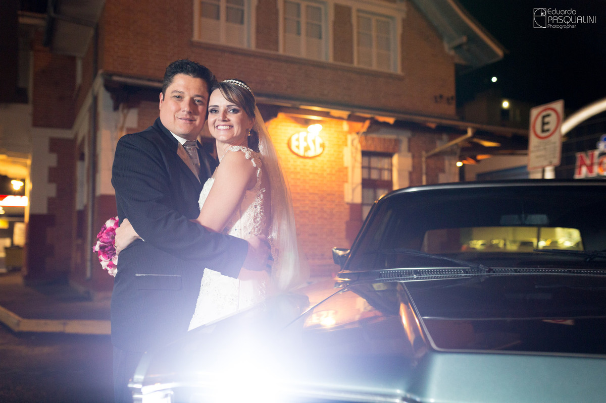 Abraçados junto ao carro antigo, noivos. Fotografia de Eduardo Pasqualini, fotógrafo de casamentos e ensaios em Rio do Sul, Santa Catarina.