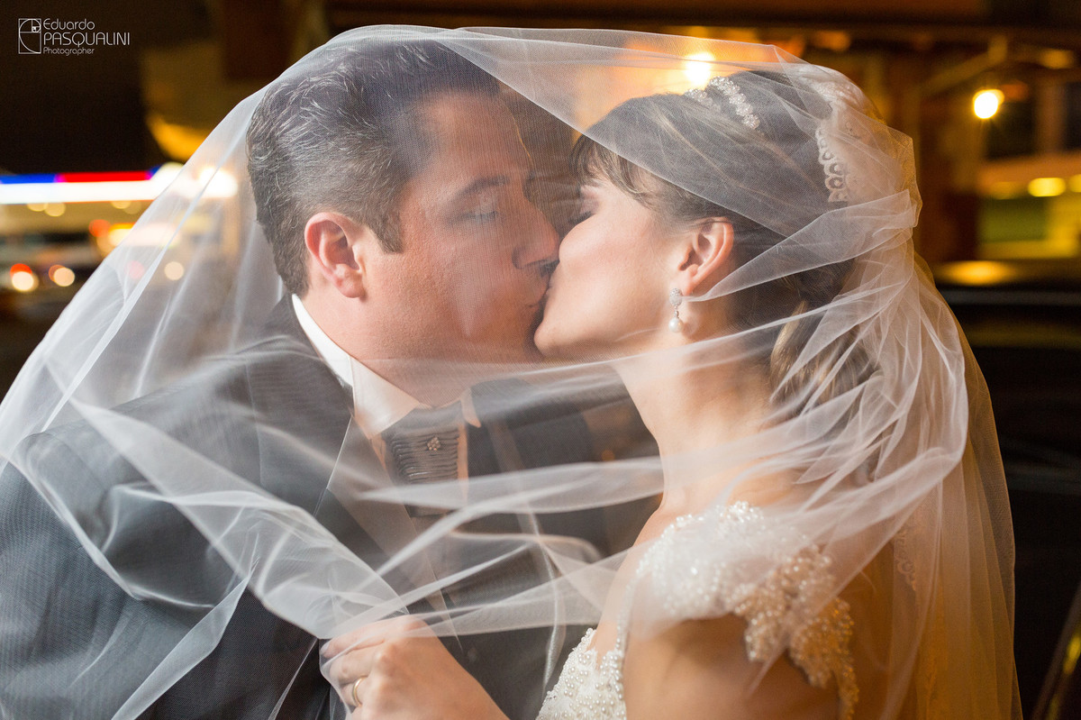 Debaixo do véu da noiva, um beijo do casal. Fotografia de Eduardo Pasqualini, fotógrafo de casamentos e ensaios em Rio do Sul, Santa Catarina.