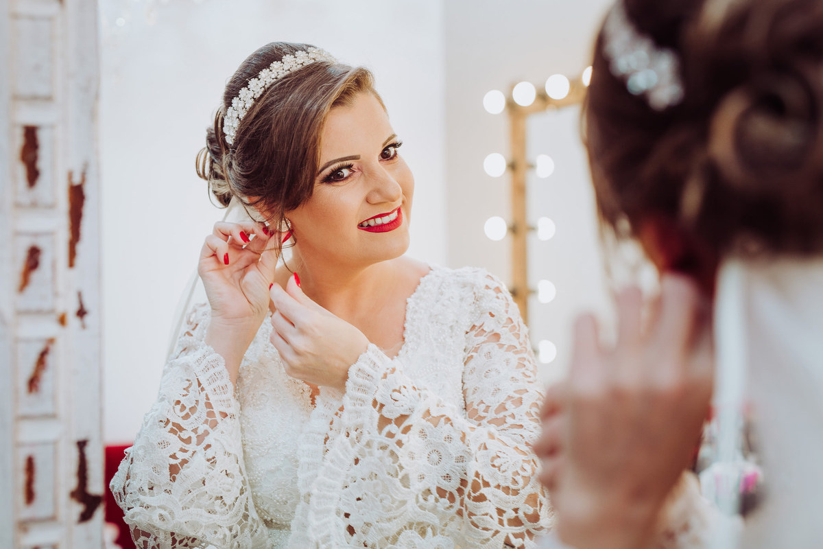 Colocando os brincos da noiva. Casamento ao ar livre, Vanessa e Daniel. Osteria La Campagnaga, Itoupava. Fotografia de Eduardo Pasqualini, fotógrafo de casamentos e ensaios em Rio do Sul, Santa Catarina.