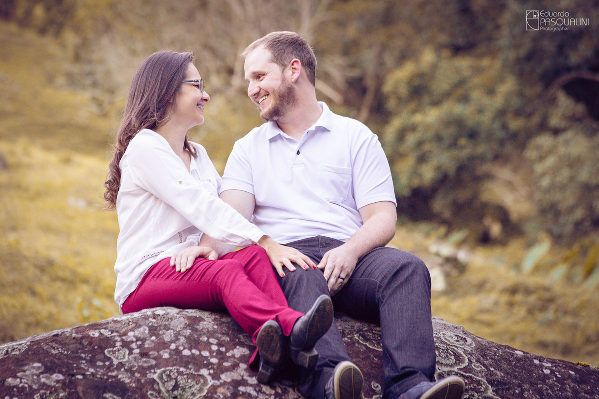 Sorrindo, casal se diverte em ensaio pré-casamento. Fotografia de Eduardo Pasqualini, fotógrafo de casamentos e ensaios em Rio do Sul, Santa Catarina.