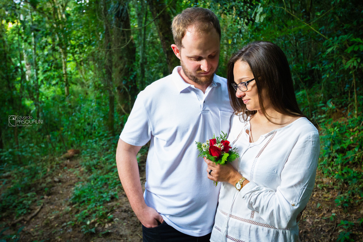 Maurício e Vanessa em meio a natureza com um pequeno buque. Fotografia de Eduardo Pasqualini, fotógrafo de casamentos e ensaios em Rio do Sul, Santa Catarina.