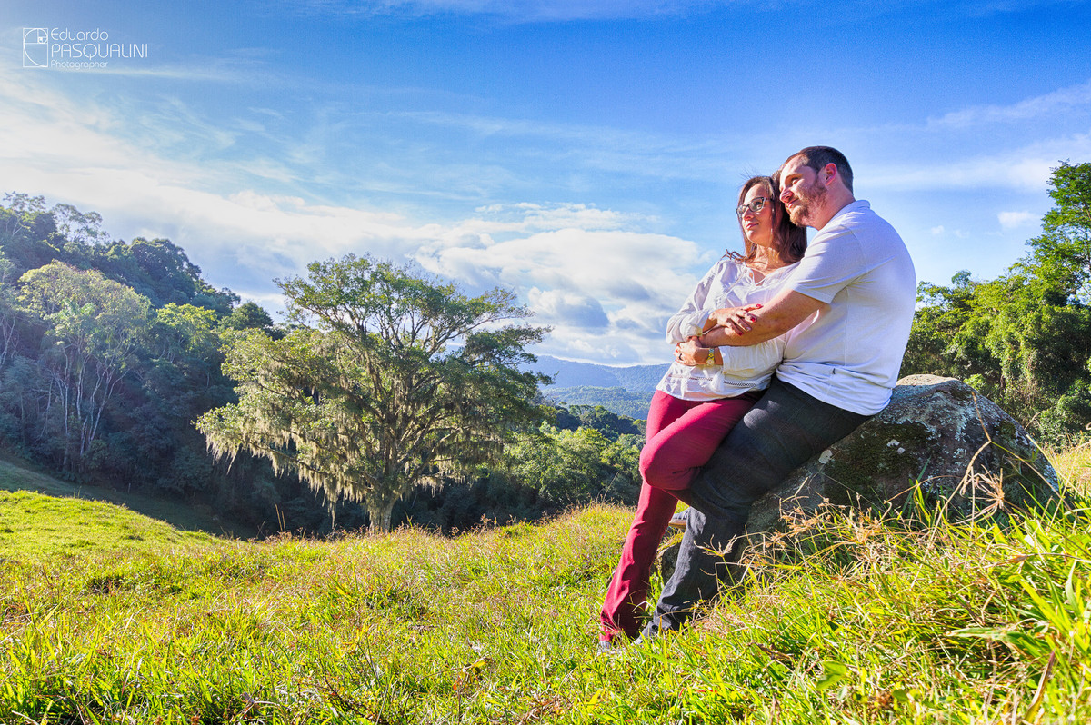 Foto de paisagem com casal abraçados. Fotografia de Eduardo Pasqualini, fotógrafo de casamentos e ensaios em Rio do Sul, Santa Catarina.