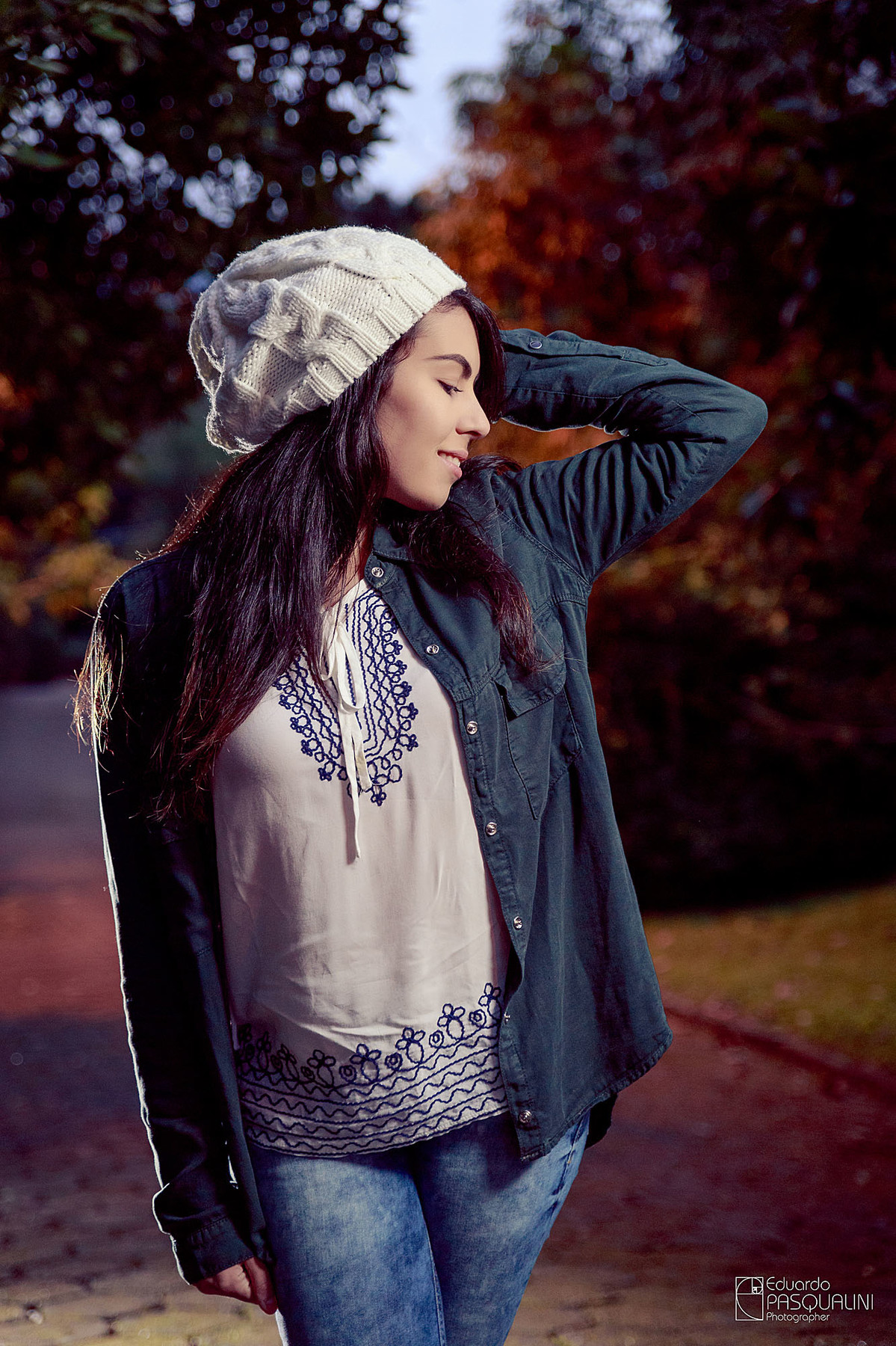 De jaqueta e gorro, modelo em pé com a mão no cabelo. Fotografia de Eduardo Pasqualini, fotógrafo de casamentos e ensaios em Rio do Sul, Santa Catarina.