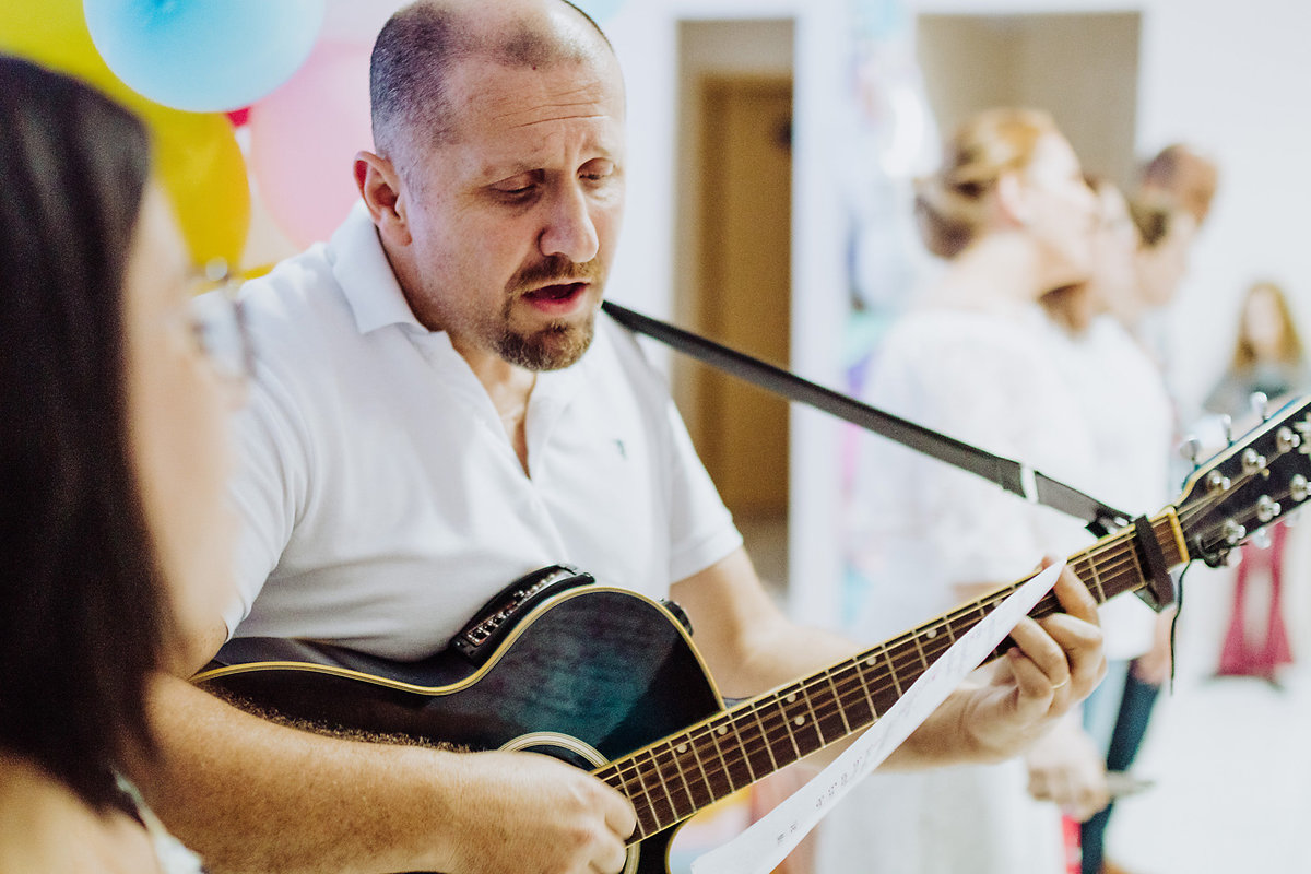 Tocando violão. Aniversário 10 anos Anna Clara. Decoração de Unicórnios. Espaço 100% festa em Rio do Sul, Santa Catarina. Fotografia de Eduardo Pasqualini, fotógrafo de família e ensaios.