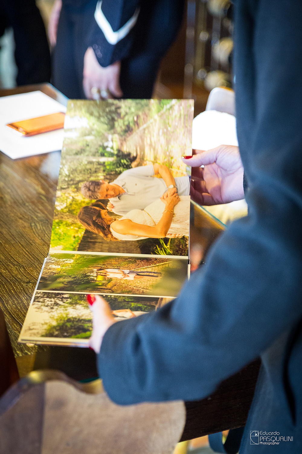 Convidados apreciando o álbum de gestação da Ângela e Anderson. Osteria La Campagnaga. Fotografia de Eduardo Pasqualini, fotógrafo de casamentos e ensaios em Rio do Sul, Santa Catarina.