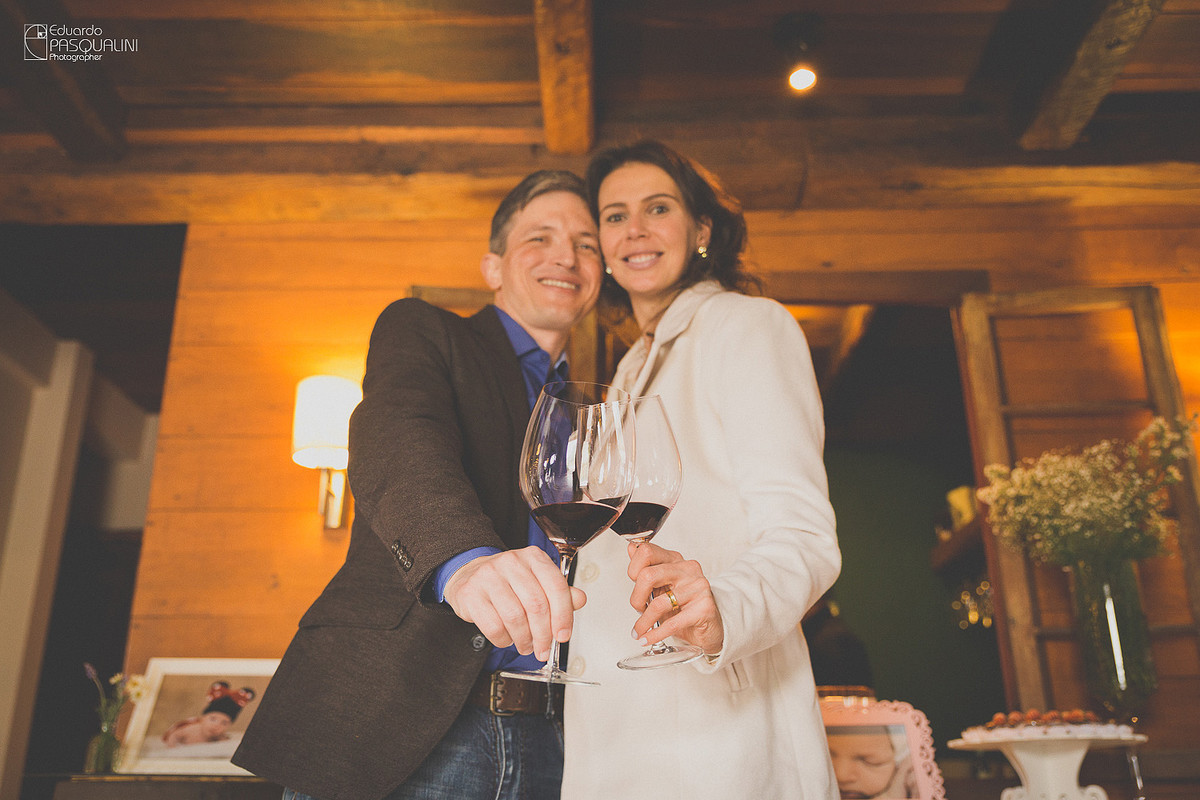 Anderson e Ângela brindando em comemoração ao batizado de sua filha Alícia. Osteria La Campagnaga. Fotografia de Eduardo Pasqualini, fotógrafo de casamentos e ensaios em Rio do Sul, Santa Catarina.