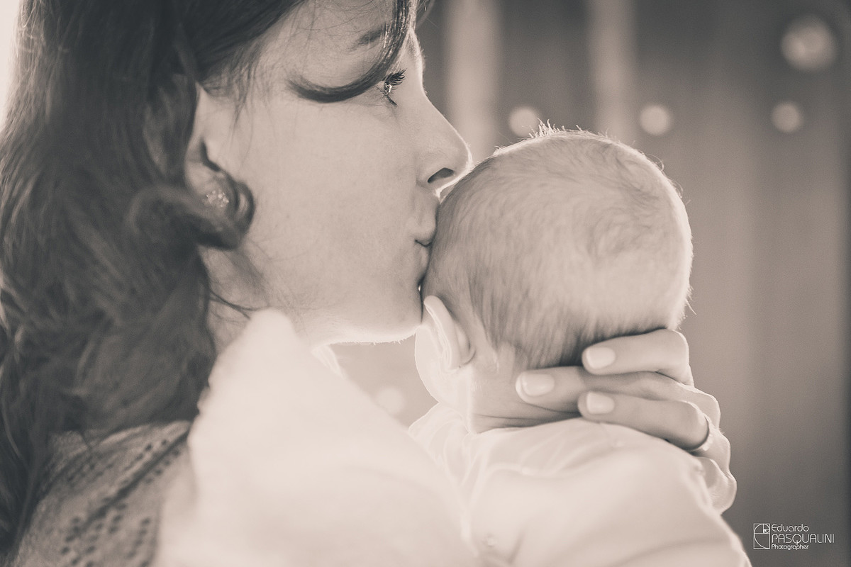 Mãe Ângela beijando bebê alícia. Osteria La Campagnaga. Fotografia de Eduardo Pasqualini, fotógrafo de casamentos e ensaios em Rio do Sul, Santa Catarina.