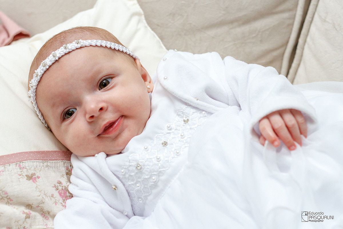 Sorrisinho de bebê Alícia em sessão de fotos. Fotografia de Eduardo Pasqualini, fotógrafo de casamentos e ensaios em Rio do Sul, Santa Catarina.