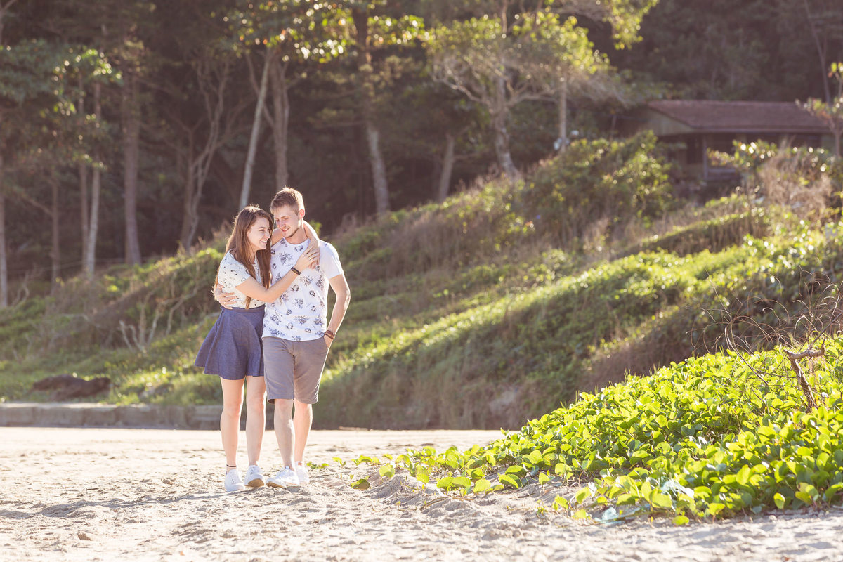 Abraçada em seu pescoço. Praia e Mar. Pré-Casamento Jaqueline e Rômulo. Navegantes, SC. Fotografia de Eduardo Pasqualini, fotógrafo de casamento, família e ensaios em Rio do Sul, Santa Catarina.