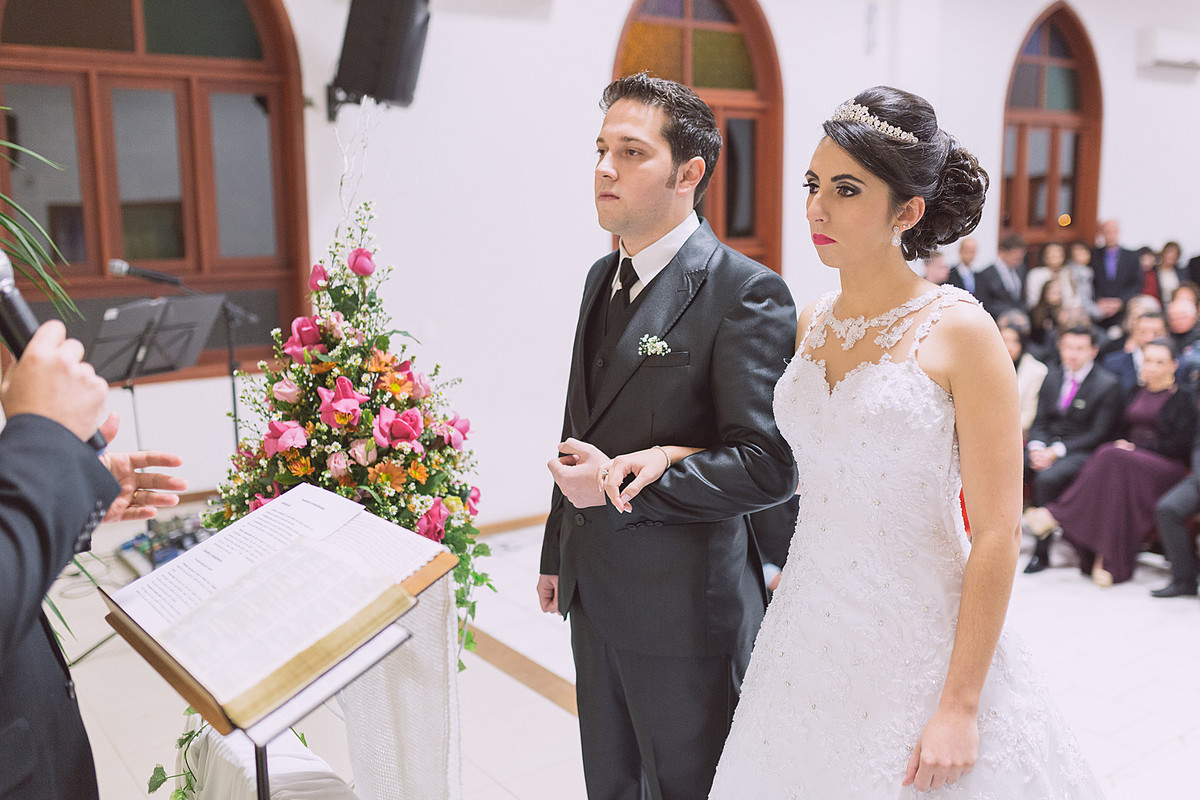 Atenciosamente, noivos escutam a palavra durante o casamento. Eduardo Pasqualini Fotografias - Fotógrafo profissional de ensaio e casamento em Rio do Sul, Santa Catarina, Brasil.