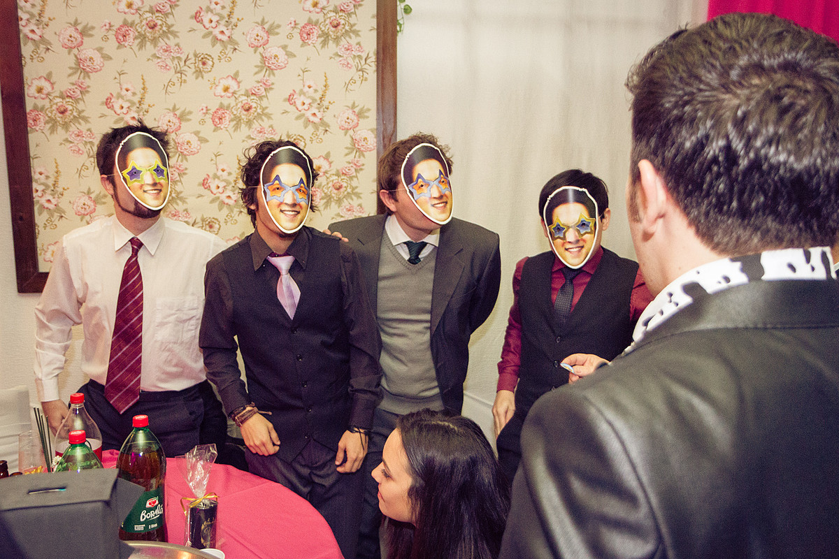 Os amigos do noivo com máscaras com o rosto do noivo. Eduardo Pasqualini Fotografias - Fotógrafo profissional de ensaio e casamento em Rio do Sul, Santa Catarina, Brasil.