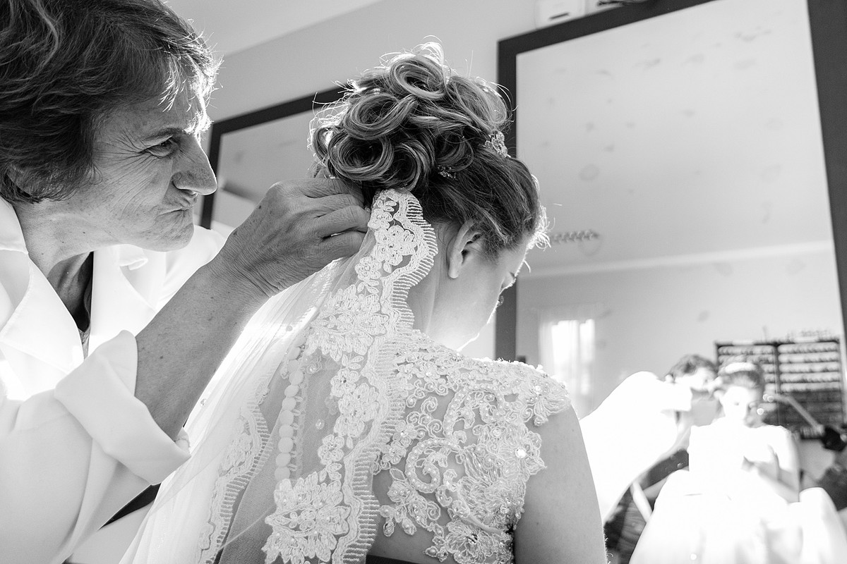Senhora prendendo o véu da noiva no cabelo. Eduardo Pasqualini Fotografias - Fotógrafo profissional de ensaio e casamento em Rio do Sul, Santa Catarina, Brasil.