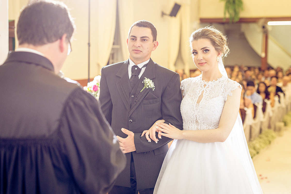 Olhando para a câmera, noiva sorri feliz durante seu casamento. Eduardo Pasqualini Fotografias - Fotógrafo profissional de ensaio e casamento em Rio do Sul, Santa Catarina, Brasil.