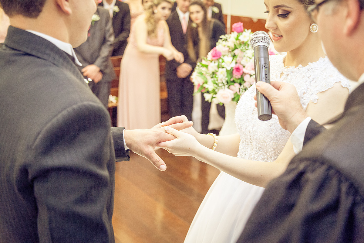 Noiva Cátia colocando a aliança na mão do noivo. Eduardo Pasqualini Fotografias - Fotógrafo profissional de ensaio e casamento em Rio do Sul, Santa Catarina, Brasil.