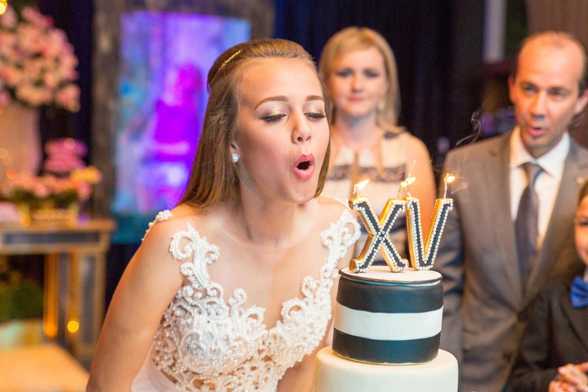 Assoprando as velinhas de XV anos. Aniversário de 15 anos. Fotografia de Eduardo Pasqualini Fotógrafo profissional de ensaio e casamento em Rio do Sul, Santa Catarina, Brasil.