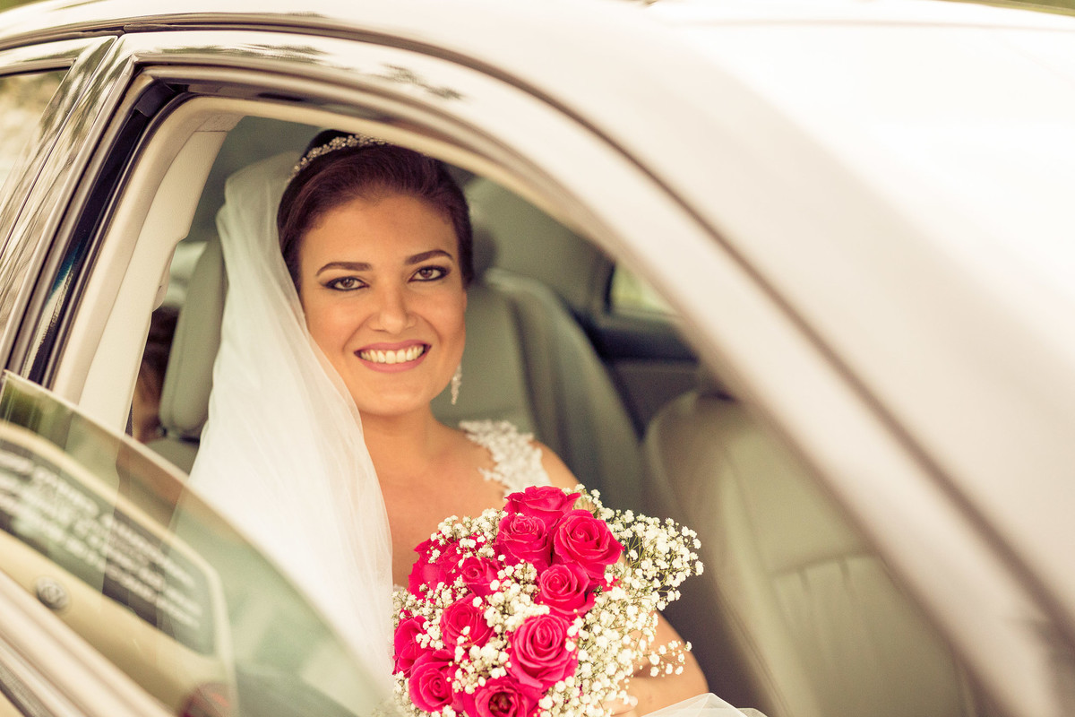 Dentro do carro, noiva feliz aguarda a sua hora. Fotografia de Eduardo Pasqualini, fotógrafo de casamentos e ensaios em Rio do Sul, Santa Catarina.