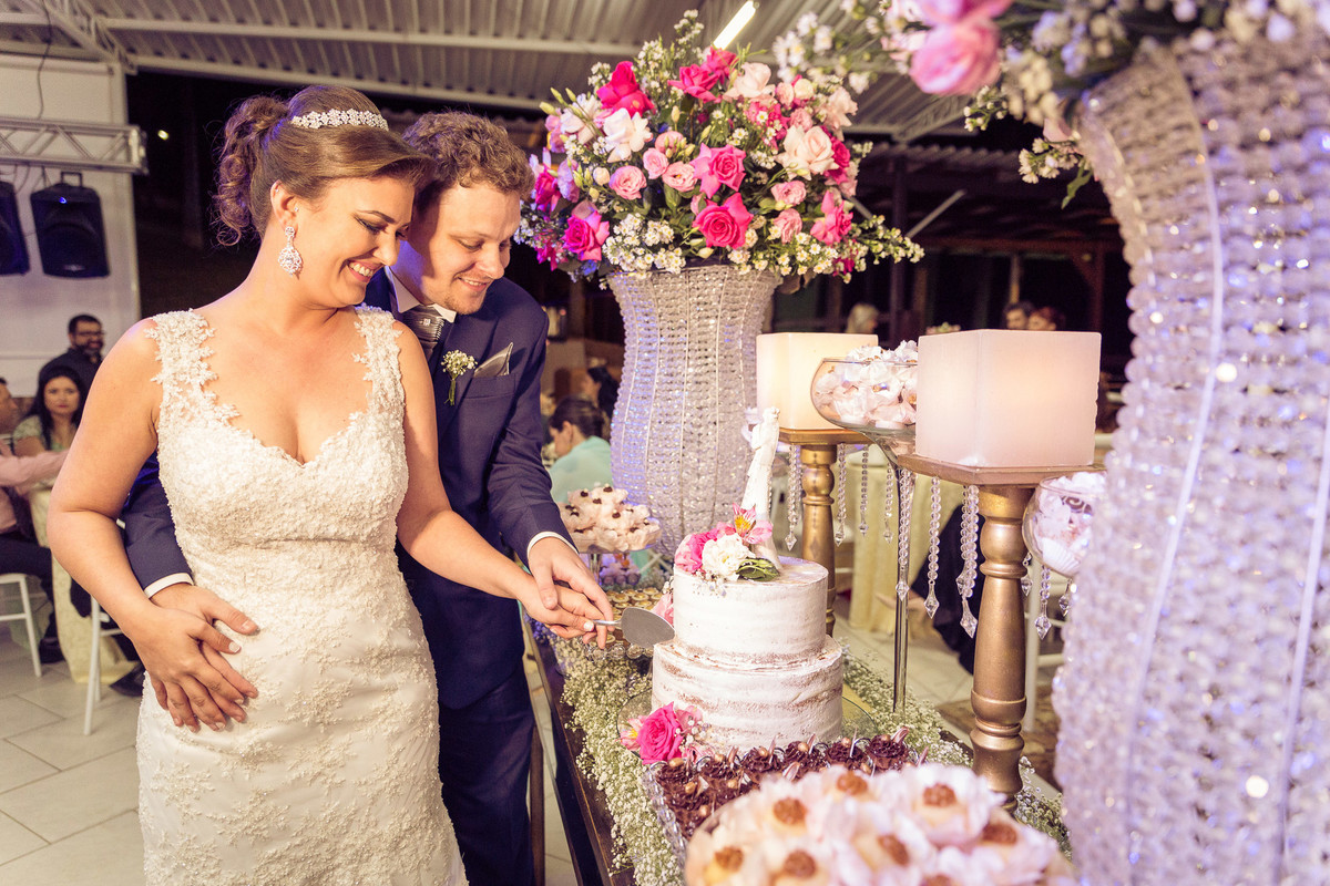 Corte do bolo no casamento de Djenifer e Gregório. Fotografia de Eduardo Pasqualini, fotógrafo de casamentos e ensaios em Rio do Sul, Santa Catarina.
