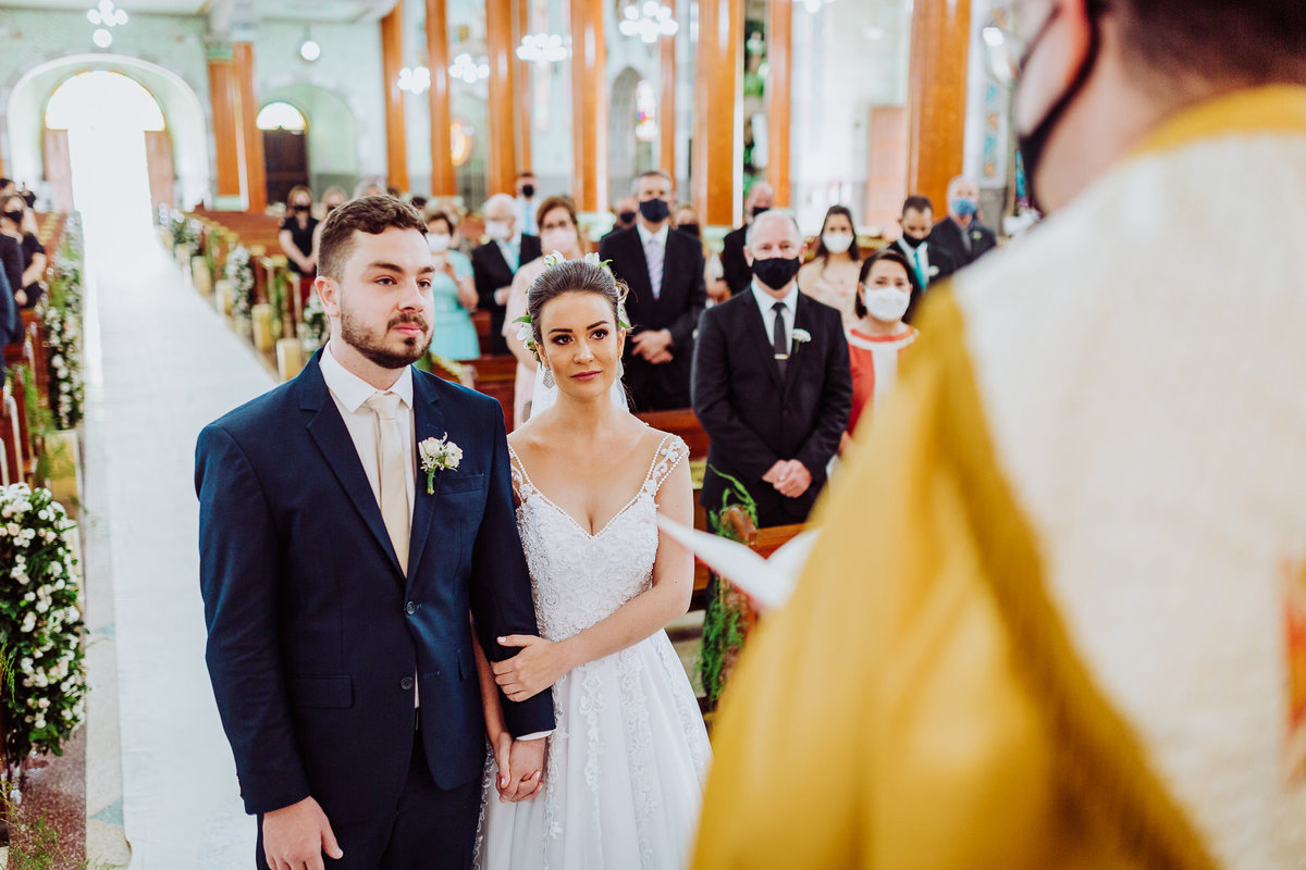 Ouvindo o padre. Casamento Giovanna e Nelso. Catedral São João Batista. Fotografia de Eduardo Pasqualini, fotógrafo de casamento, família e ensaios em Rio do Sul, Santa Catarina.