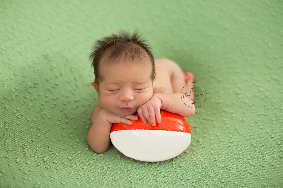 fotografia de recem nascido com bola de rugby